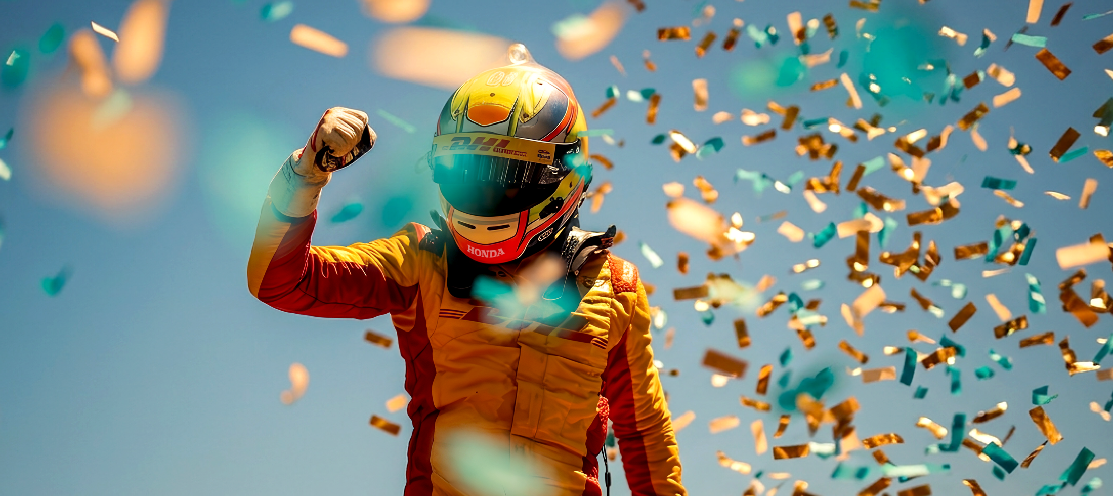 Race car driver in yellow suit and helmet with fist in the air.