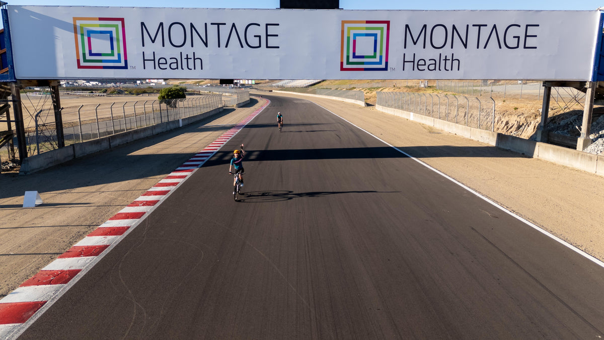 Cyclists riding beneath the Montage Health bridge at WeatherTech Raceway Laguna Seca